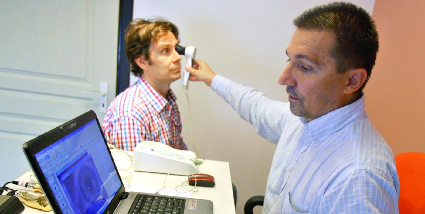 
    Dr. Rareş Simu pune diagnosticul unui pacient  cu ajutorul iridoscopului  
