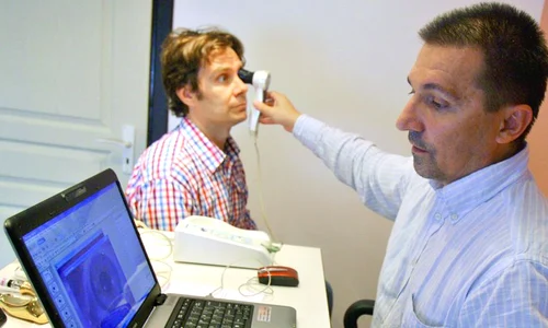Dr  Rareş Simu pune diagnosticul unui pacient  cu ajutorul iridoscopului jpeg