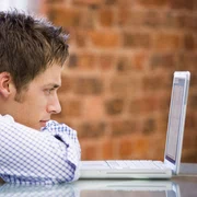 shutterstock 11084980 baiat plictisit birou calculator laptop jpeg