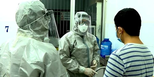 Oficiali de la Ministerul Sănătăţii din Vietnam discută cu un pacient depistat pozitiv în spitalul din oraşul Ho Chi Minh. FOTO EPA-EFE Cho Ray