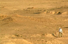 Zona de studiu Middle Awash, Riftul Afar din Etiopia, cu sedimente expuse orizontal în prim-plan, conținând mii de fosile și artefacte din perioada Paleoliticului Mijlociu (© Tim White)