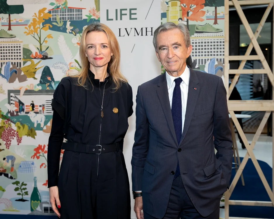 Bernard Arnault alături de fiica sa Delphine cu spatele la un panou pe care scrie Life LVMH