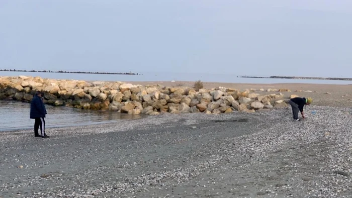 Bărbaţi plimbându-se în papuci pe plaja de la Flora, în Mamaia Sursa localnic