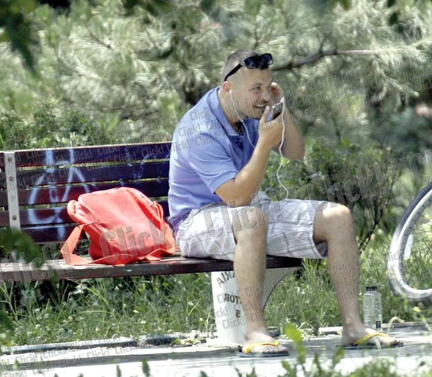 Cântăreţul Puya ascultă, cu atenţie, muzică la căştile telefonului, după ce a poposit pe o bancă