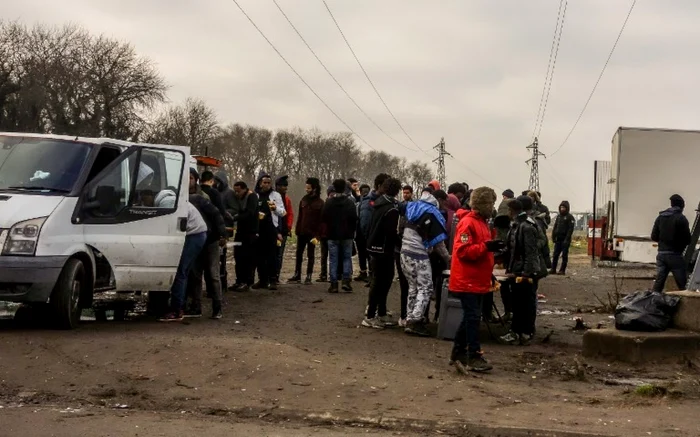 Migranţi stau la coadă în Calais pentru a primi ajutoare FOTO AFP