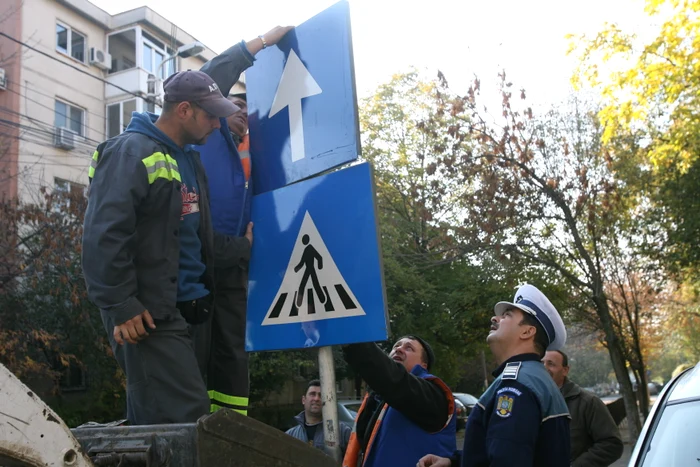 
    Angajaţii de la Administraţia Străzilor, supravegheaţi de poliţişti, au montat indicatoarele rutiere specifice (foto: Arhivă)  