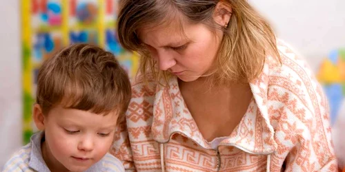 O mamă îşi ajută băieţelul să descifreze tainele cărţilor