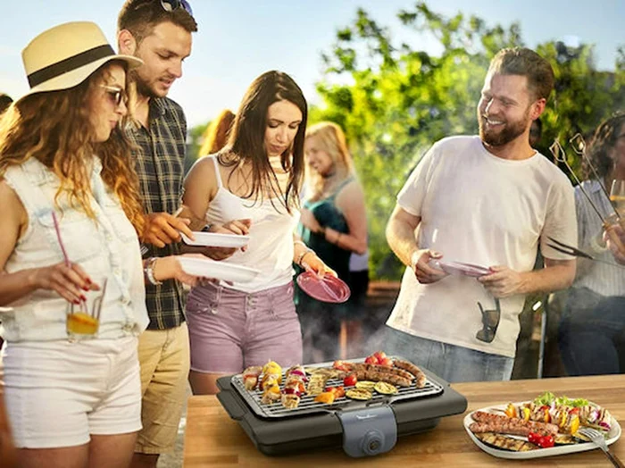 Grătar electric în mijlocul unui grup de petrecăreți pe terasă Foto Skroutz.ro