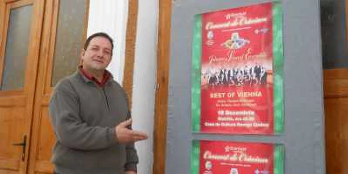 Portarul Centrului Cultural Municipal, Ionel Ursuţ, arată afişul de la intrare 