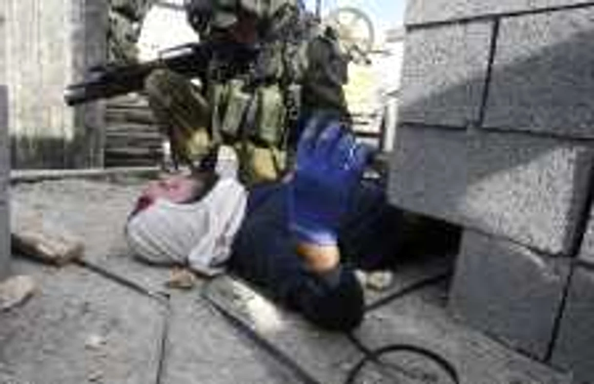 Un soldat israelian îngenunchează lângă un evreu sechestrat de palestinienii din Qusra. FOTO Reuters