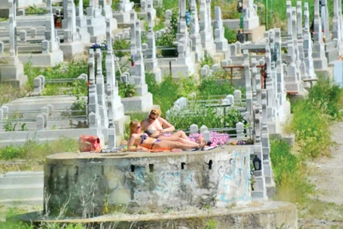 
    Dornice de un bronz  de invidiat, cele două  femei  nu par deranjate  de crucile din jurul lor  (FOTOGRAFII: Botoşăneanul)  
