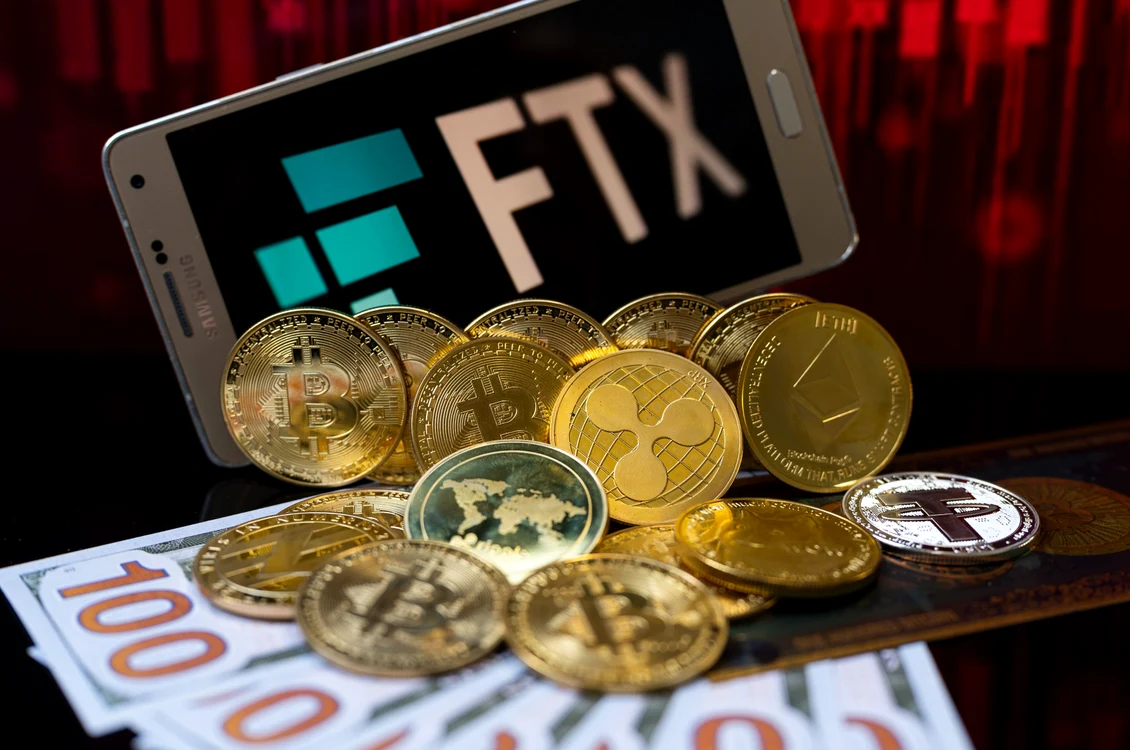 monede și bancnote virtuale pe un portofel lângă un telefon pe care este afișat FTX