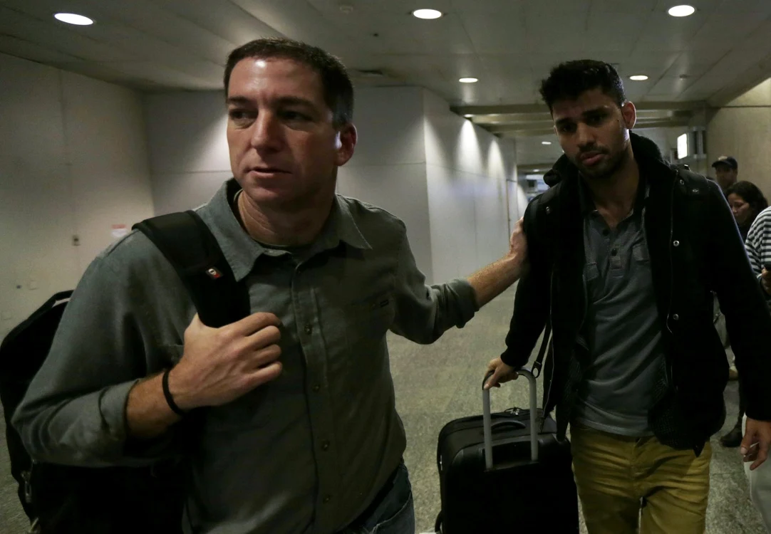 Jurnalistul Glenn Greewnwald împreună cu David Miranda, la plecarea de pe aeroportul Heathrow. FOTO: Reuters