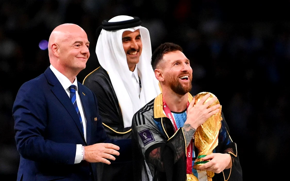 Messi, cu Cupa Mondială în brațe, îmbrăcat în Bisht, alături de Emirul Qatarului și de șeful FIFA.