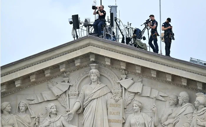 Lunetiști pe acoperișul Parlamentului, în timpul ceremoniei de deschidere a JO. Foto AFP
