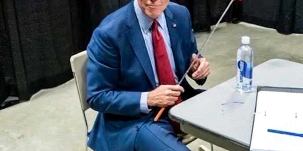 Biden tinand un plici de muste in mana
