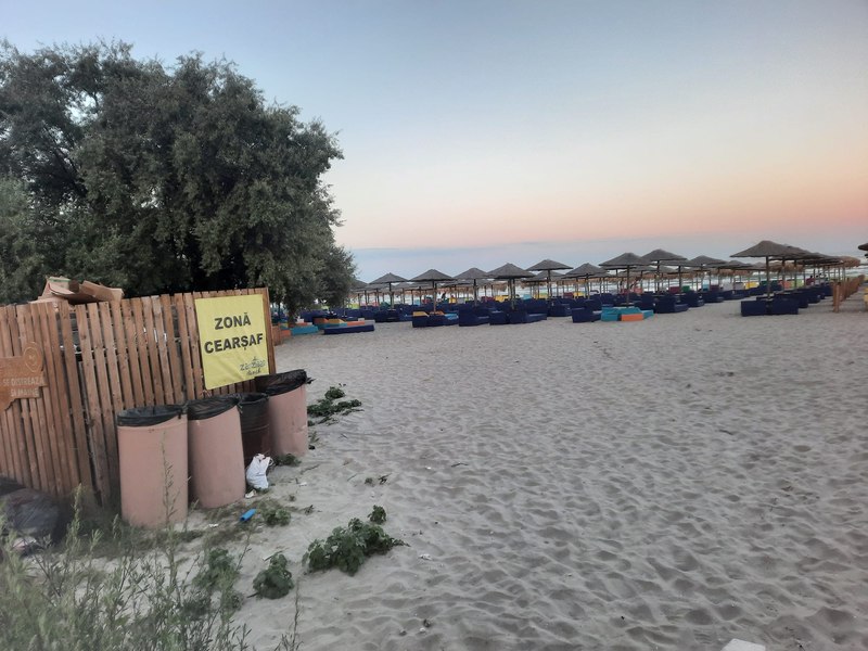 Umilirea turiștilor pe plajele de fițe din Mamaia Nord: zona de cearșafuri lângă gunoaie