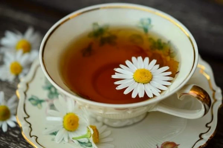 A ​steaming cup of chamomile tea with chamomile‌ flowers