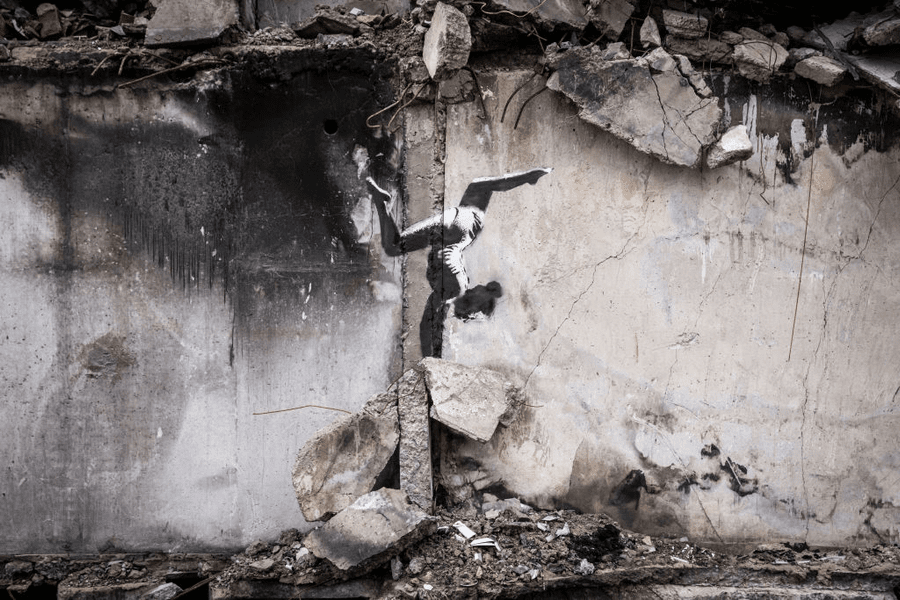 Graffiti realizat de Banksy, pe o clădire distrusă de bombe în Ucraina: o gimnastă stând în mâini pe moloz | FOTO