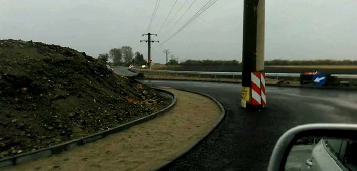 Pe acest drum se circulă în regim de şantier, iar stâlpul este ocolit de şoferi FOTO: Facebook/Dan Păloiu