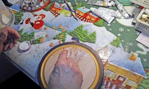 Pensionarul lipeşte cojile de ouă pe o bucată de lemn jpeg