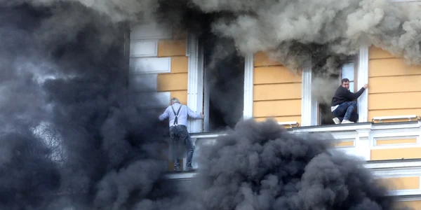 Doi bărbați încearcă să scape din clădirea Academiei Naționale de Științe, cuprinsă de flăcări în urma unui atac cu dronă rusească la Kiev