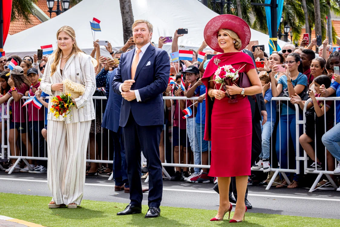 Amalia (foto stânga) alături de Regele și Regina Țărilor de Jos, lcu un buchet în mână