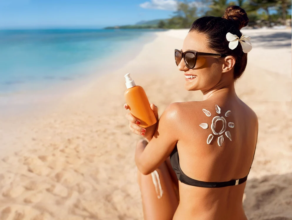 Femeie pe nisip cu un soare desenat din cremă cu SPF Foto Holiday inn Pattaya jpg