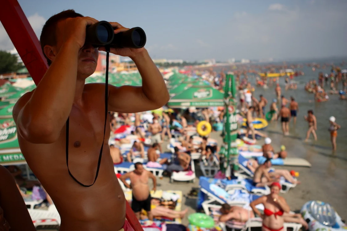 Plaja mare litoral staţiuni turişti soare bronzat nisip umbrele şezlonguri salvamar Sursa arhivă