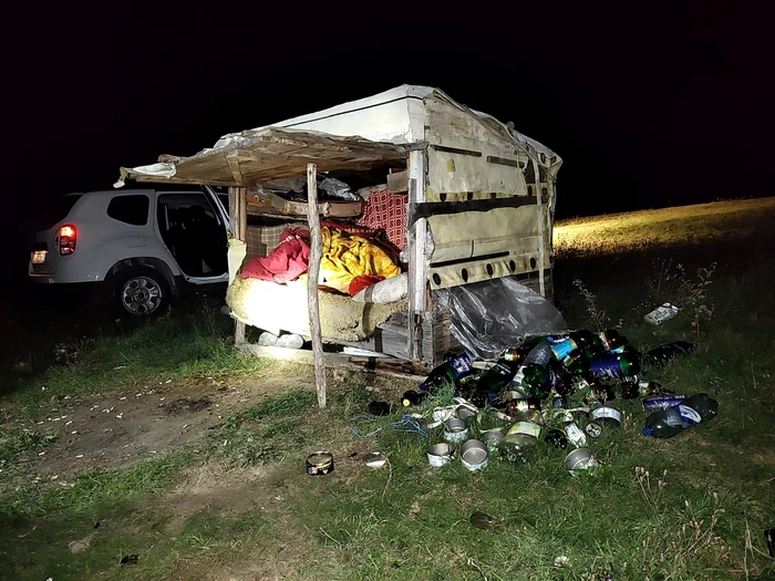 Adăpost improvizat din lemn cu pături și gunoaie