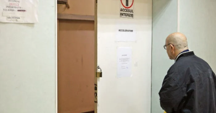 Pacient în faţa afişului prin care este anunţat că aparatul de radiologie nu funcţionează