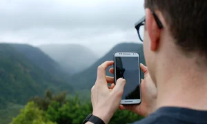 barbat cu smartphone in natura jpg