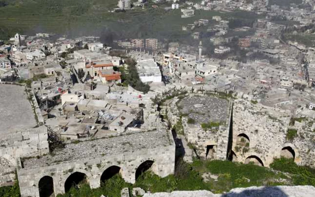 Panoramă asupra Crac des Chevaliers, în timp ce fumul se ridică deasupra locuinţelor din Hosni. Cetatea a fost cucerită de soldaţii lui Bashar al Assad  în luna martie. FOTO Reuters