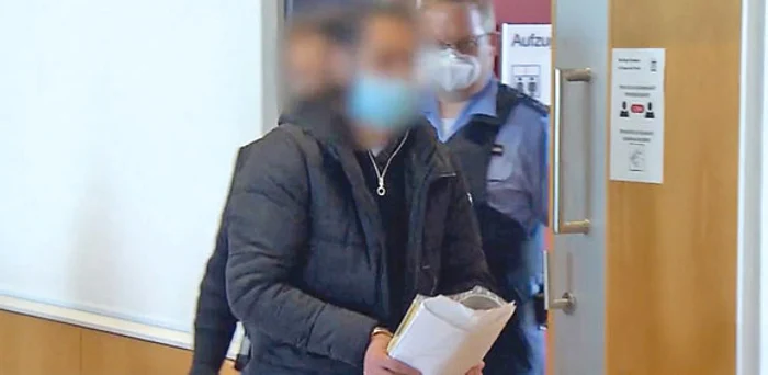 Flori şi o candelă la intrarea în bloc