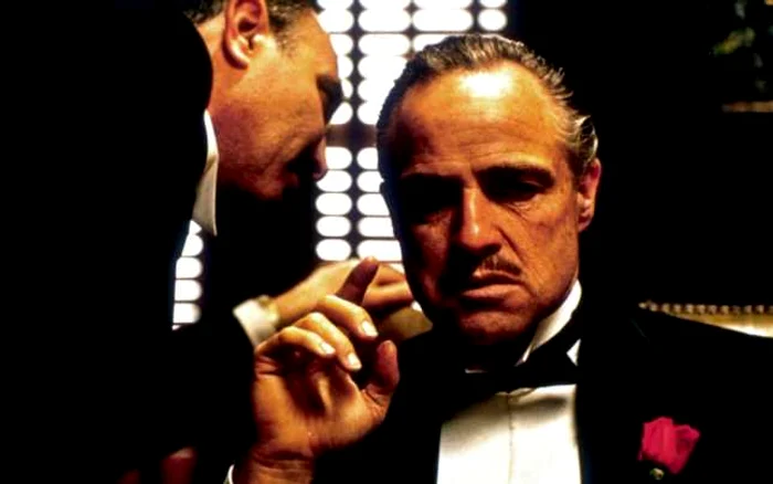 În prim plan, Marlon Brando: scenă de la începutul capodoperei Godfather, ecranizată după un roman scris de Mario Puzo