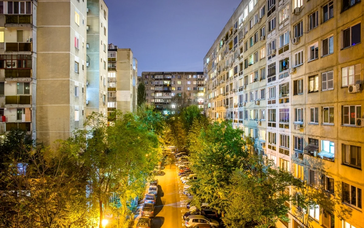 Alee frumos luminată între mai multe blocuri înalte din București