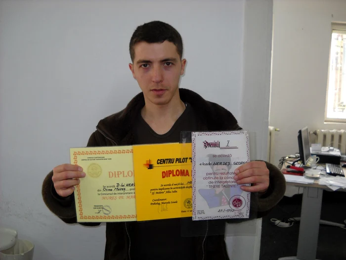 George Herdeş prezintă diplomele obţinute la diverse concursuri