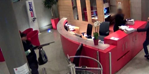 O captura de pe camera de supraveghere arata un suspect inarmat (s). Politia a dat in urmarire o persoana inarmata care a patruns luni in brorurile ziarului Liberation si intr-o banca importanta inainte de a deturna o masina care l-a lasat pe bulevar