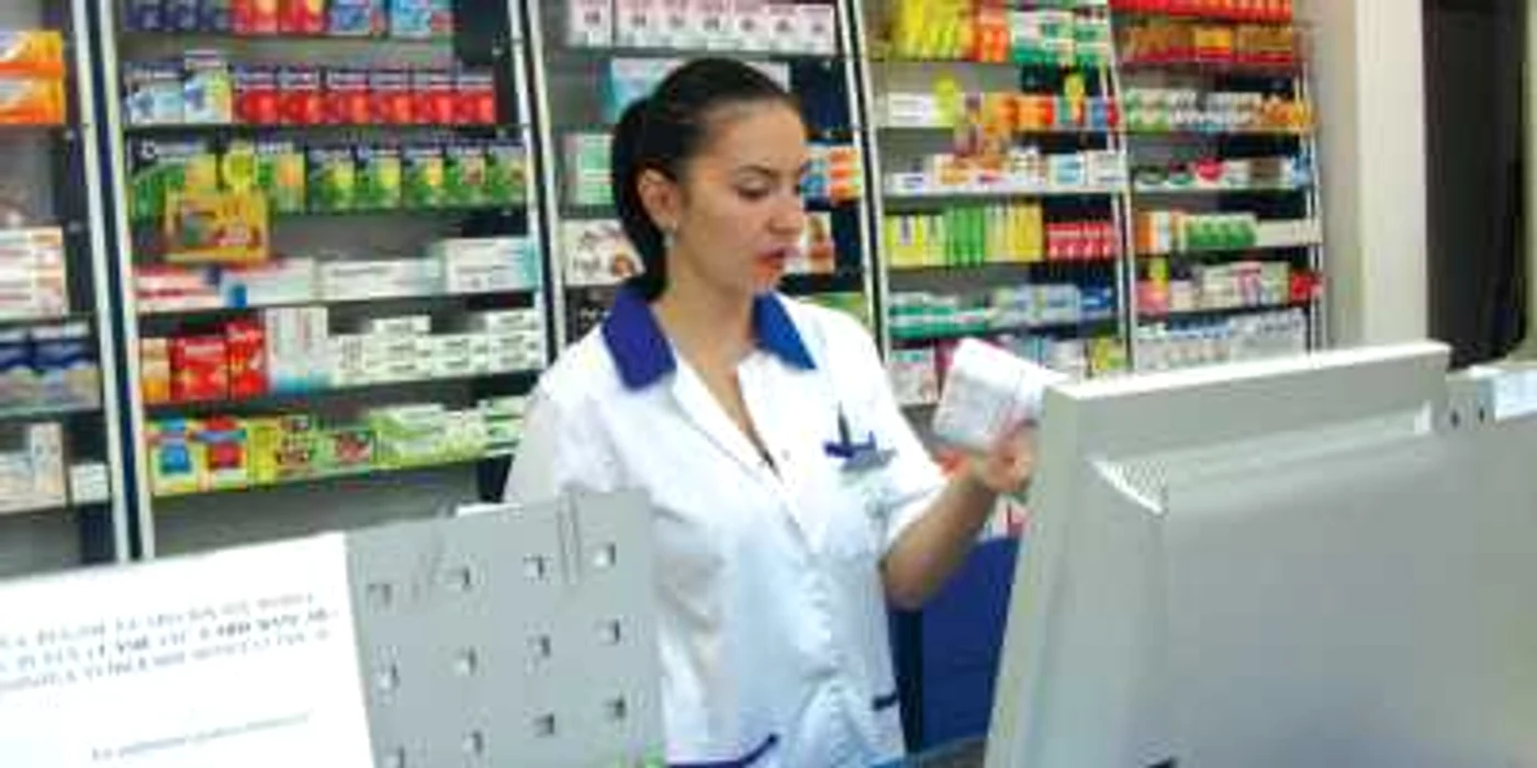 Farmaciştii sunt ocupaţi cu lipirea etichetelor noi cu preţuri pe cutiile cu medicamente