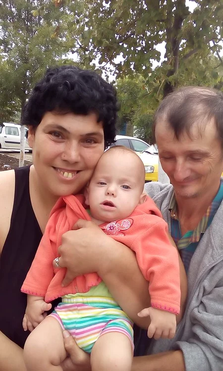 Micuțul, în brațele nașei