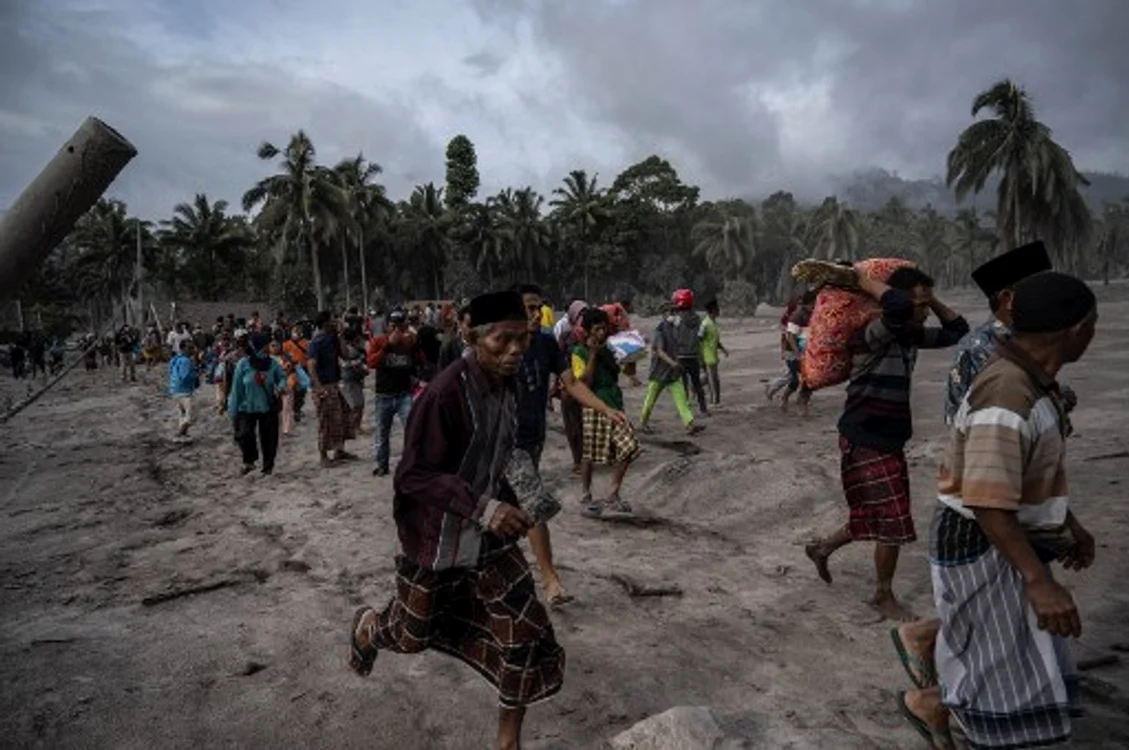 Oameni fugind din calea cenușei care a acoperit sate întregi după erupția vulcanului Semeru din Indoneziafoto: AFP