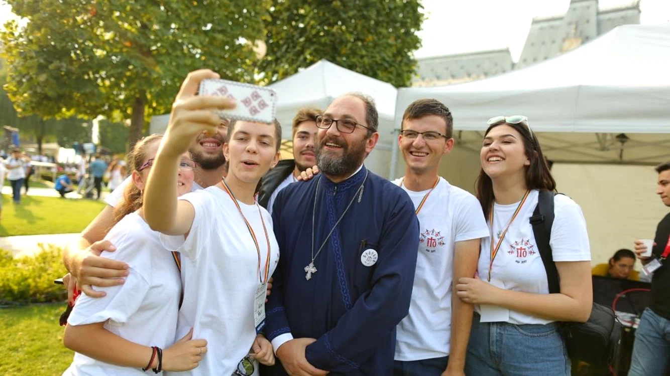 Părintele Constantin Necula, înconjurat de tineri. Sursă foto: Basilica.ro