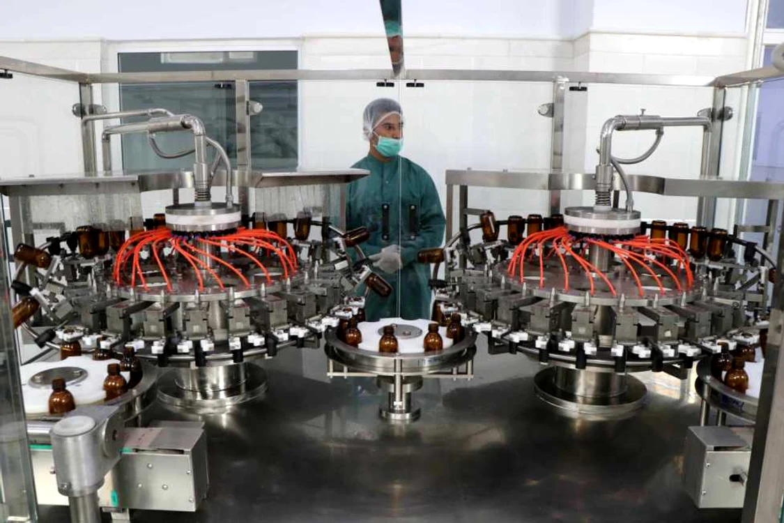 Un muncitor supraveghează împachetarea sticlelor de medicamente în fabrica Sina Pharmaceutical. FOTO EPA-EFE