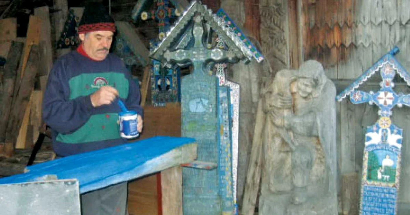 Meşterul Mitică Pop, în atelierul său de sculptat şi pictat cruci din lemn  