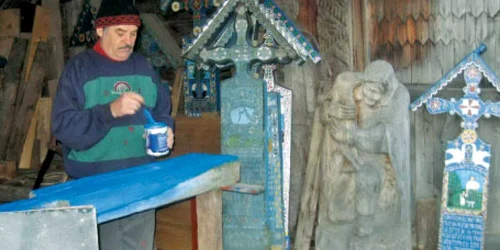 Meşterul Mitică Pop, în atelierul său de sculptat şi pictat cruci din lemn  