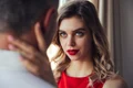 serious woman flirting hug her man while posing near window jpg