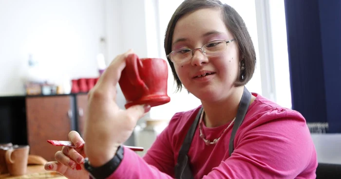 Mihaela are Sindromul Down, însă acest lucru nu o împiedică să picteze cu dăruire vasele de ceramică FOTO Adevărul