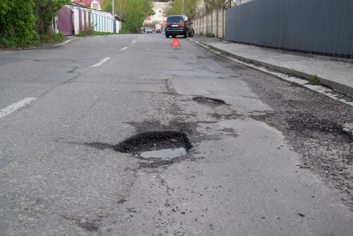 Şoferul şi-a distrus două anvelope în groapa din asfalt. Foto Adevărul