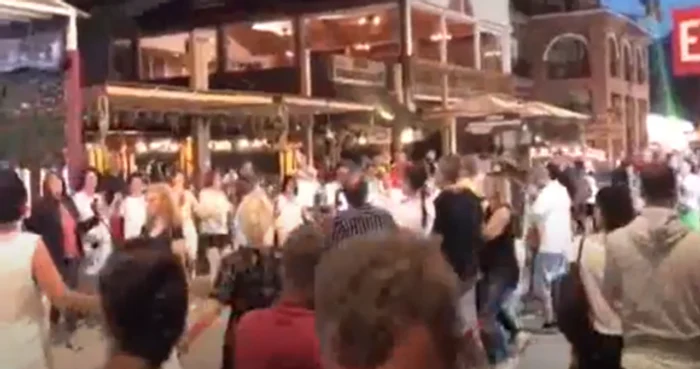 În fața unei terase,  oamenii au încins o horă