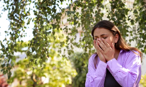 woman suffering from allergies outside jpg
